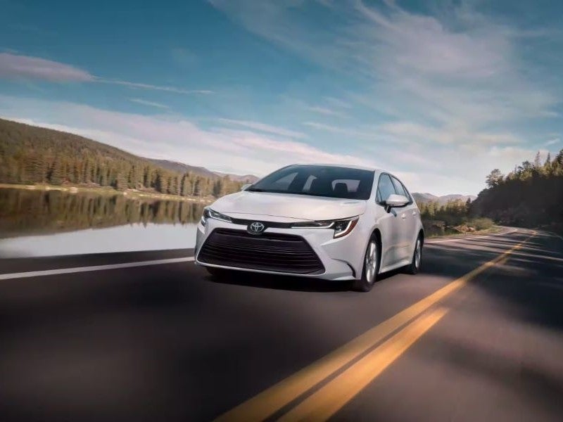White Toyota Corolla driving on street