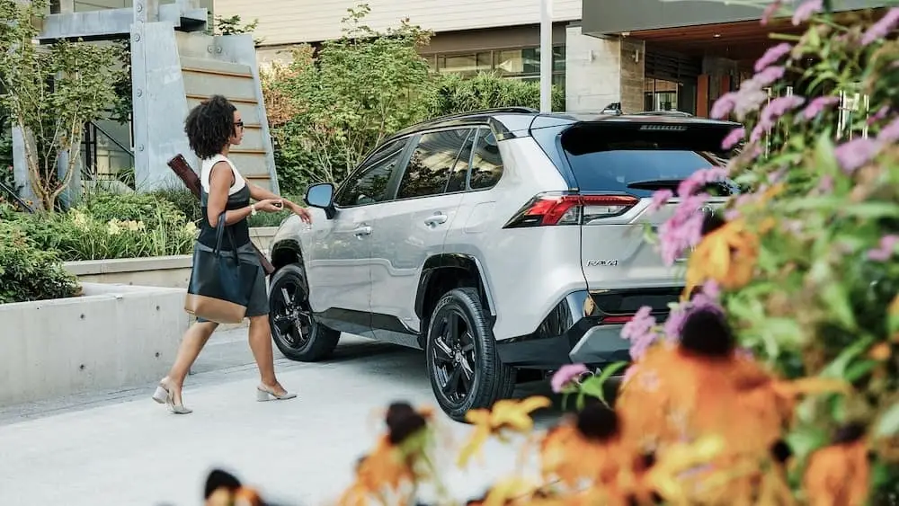 Woman reaching for the door of a Toyota Rav4